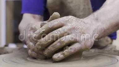 波特用粘土做成盘子。 库存录像。 男人`专业的陶工手，用陶工`陶工的陶工装泥